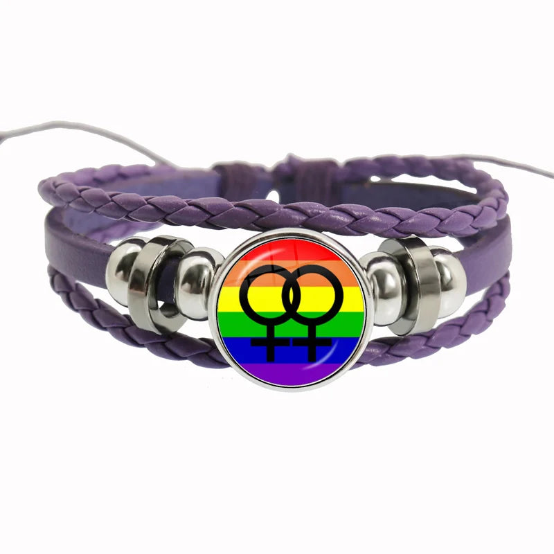 Ein Lederarmband mit geflochtenem Design und einem runden Anhänger in den Farben der Regenbogenflagge und Lesbensymbol. Verziert mit silbernen Akzenten und perfekt als LGBTQ+-Pride-Schmuck.