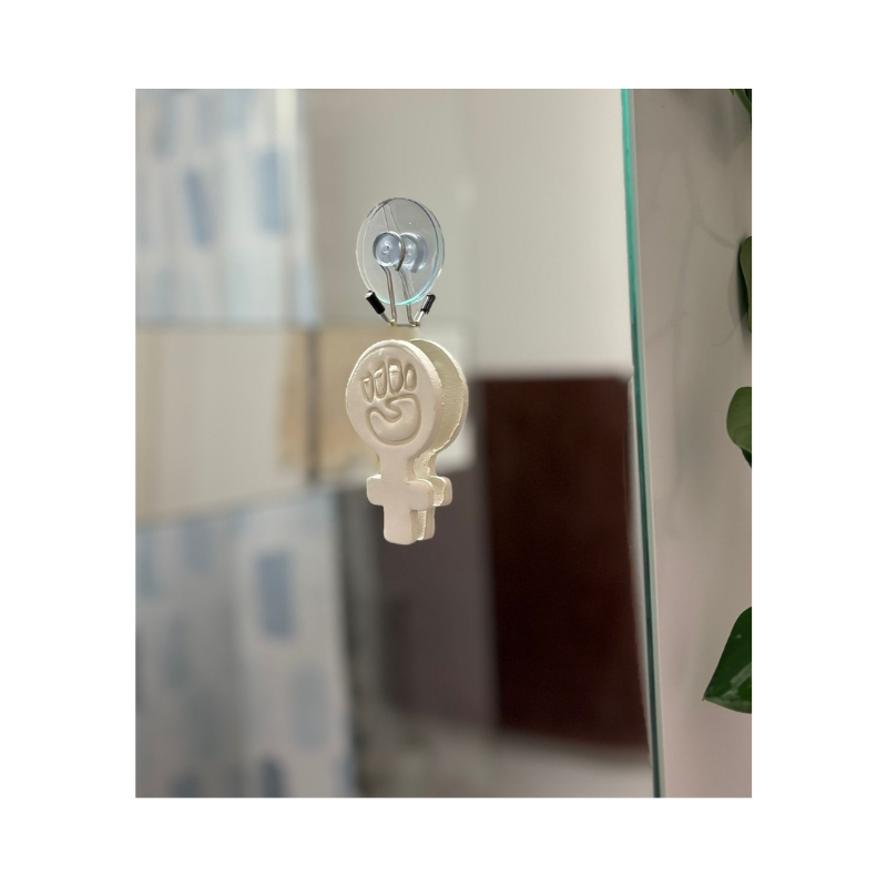 Handgefertigtes feministisches 3D-Wandbild aus Modelliermasse, aufgehängt im Wohnraum mit transparenter Wandhalterung