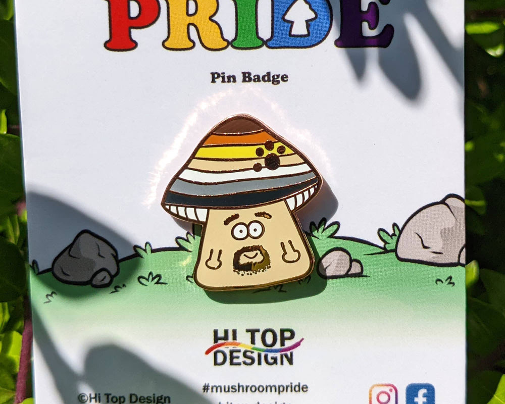 Detailaufnahme Bear Pride Mushroom Emaille Pin mit Pilz Motiv auf Verpackung – LGBTQIA+ Anstecknadel in Nahaufnahme