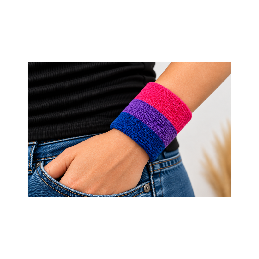 Bisexual Pride Schweissband in Pink, Violett und Blau am Handgelenk getragen, kombiniert mit blauer Jeans und schwarzem Oberteil