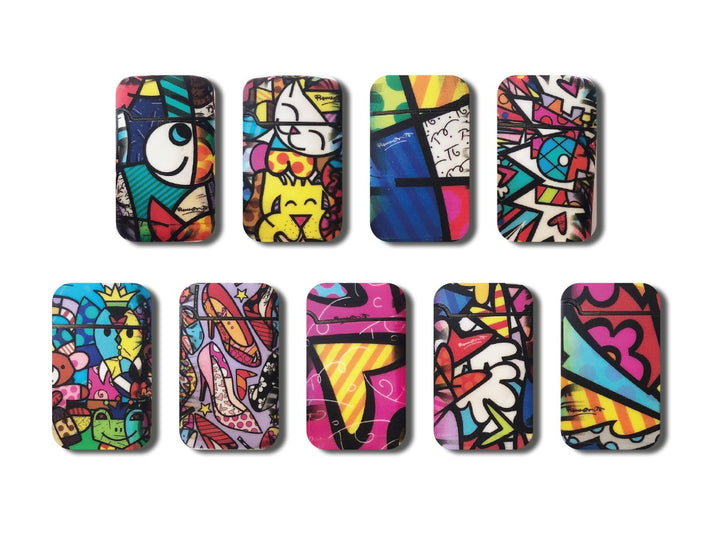 Jet-Flame-Feuerzeugen der Marke BRITTO, gestaltet im ikonischen Pop-Art-Stil von Romero Britto. Die Feuerzeuge zeigen lebendige Muster mit kräftigen Farben, abstrakten Formen und Motiven wie Herzen, Augen und Schmetterlingen. Die gelbe Verpackung ist ebenfalls mit kleinen Schmetterlingen verziert und trägt die Aufschrift „Jet Flame – High Quality – Refillable Lighter“ sowie „Easy Torch“ für einfache Handhabung.