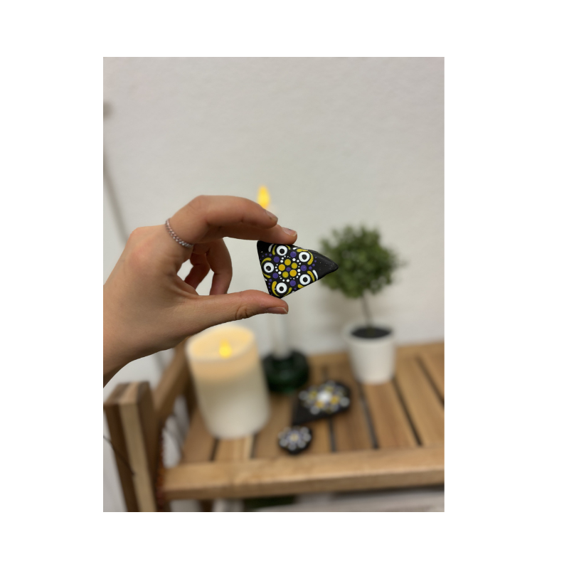 Hand hält handbemalten Dotting-Stein im Nonbinary-Pride-Design, dekorativer Kunststein mit Punktmuster