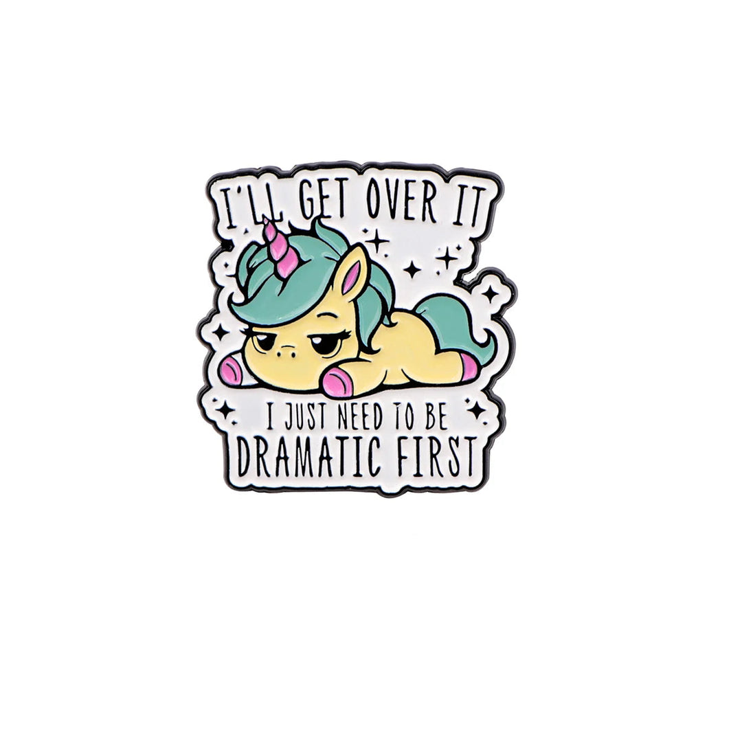 Einhorn Ansteck-Pin mit dem Text „I’ll get over it. I just need to be dramatic first“ und pastellfarbenem Einhorn-Motiv.