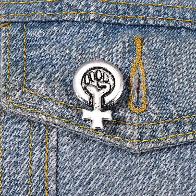 Feminismus Pin mit Power-Faust-Symbol an einer Jeansjacke getragen

