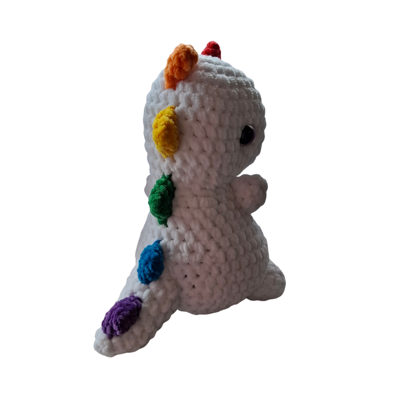 Gehäkelter Regenbogen Dino Pride Kuscheltier Handmade aus der Schweiz Seitenansicht mit bunten Pride Spikes und weißem Körper