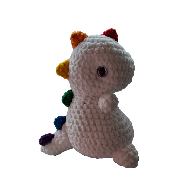 Gehäkelter Regenbogen Dino Pride Kuscheltier Handmade aus der Schweiz Seitenansicht mit bunten Pride Spikes und weißem Körper