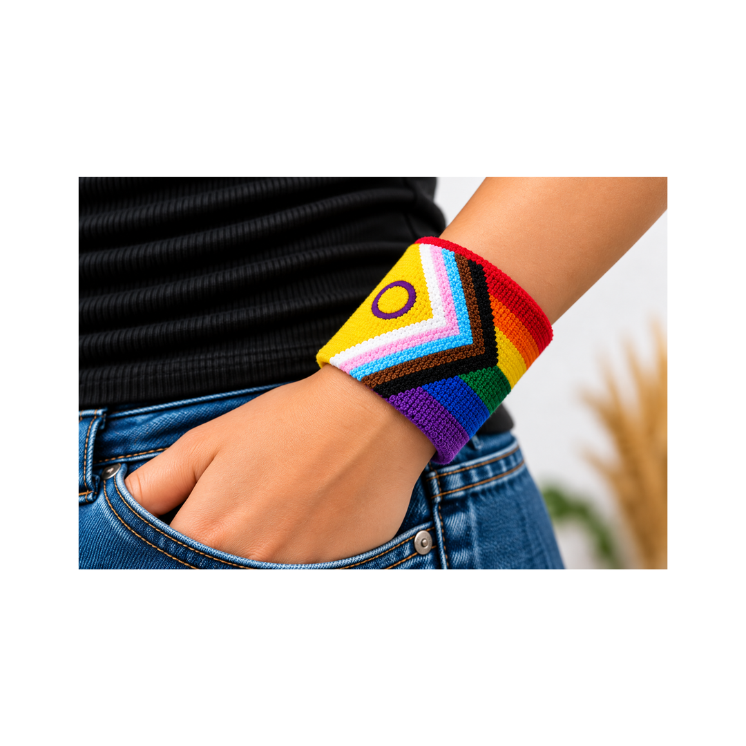 Intersex Inclusive Progress Pride Schweissband mit Regenbogenstreifen und violettem Intersex-Kreis, getragen am Handgelenk zu Jeans und schwarzem Oberteil