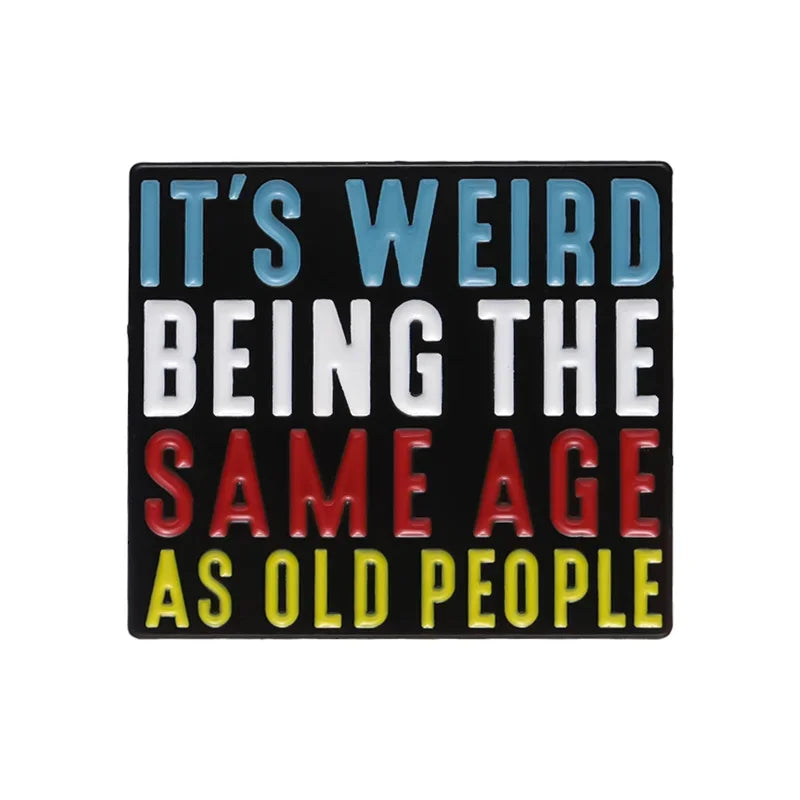 Rechteckiger Pin mit buntem Text It's Weird Being the Same Age as Old People auf schwarzem Hintergrund