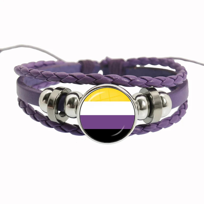 Ein Lederarmband mit geflochtenem Design und einem runden Anhänger in den Farben der Non-binären Flagge. Verziert mit silbernen Akzenten und perfekt als LGBTQ+-Pride-Schmuck.