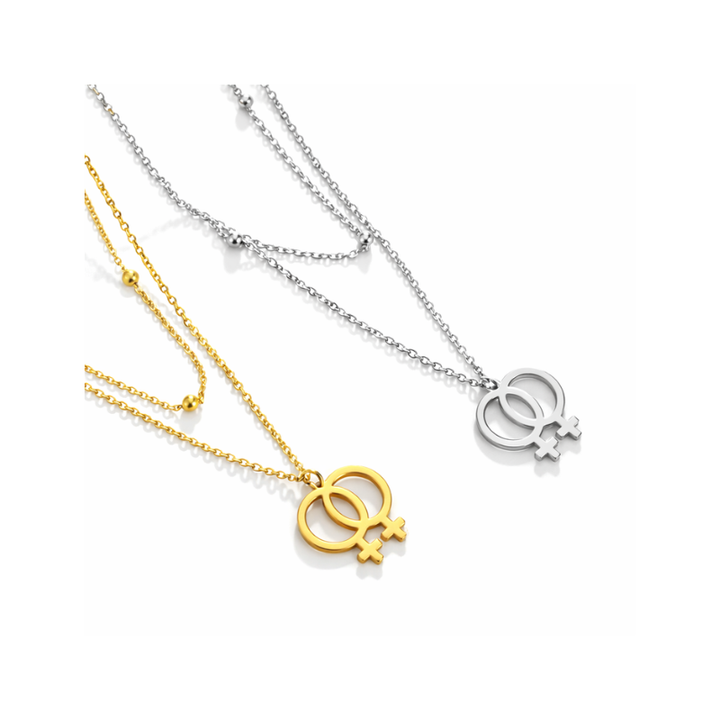 Zwei Halsketten mit lesbischem Symbol, eine in Gold und eine in Silber, mit ineinandergreifenden Venuszeichen auf feiner Kette.
