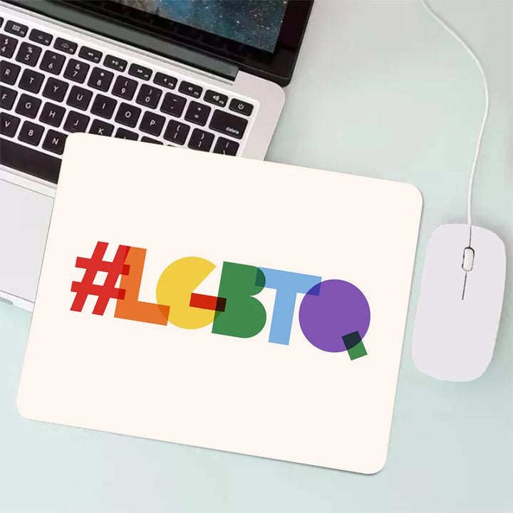 Weißes Mauspad mit dem farbenfrohen Hashtag ‚#LGBTQ‘, platziert neben einem Laptop und einer Maus