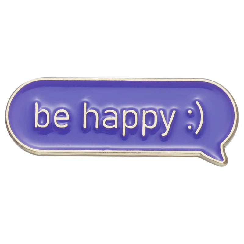 Lila Sprechblasen-Pin mit der weißen Aufschrift „be happy :)“ in moderner, klarer Schrift.