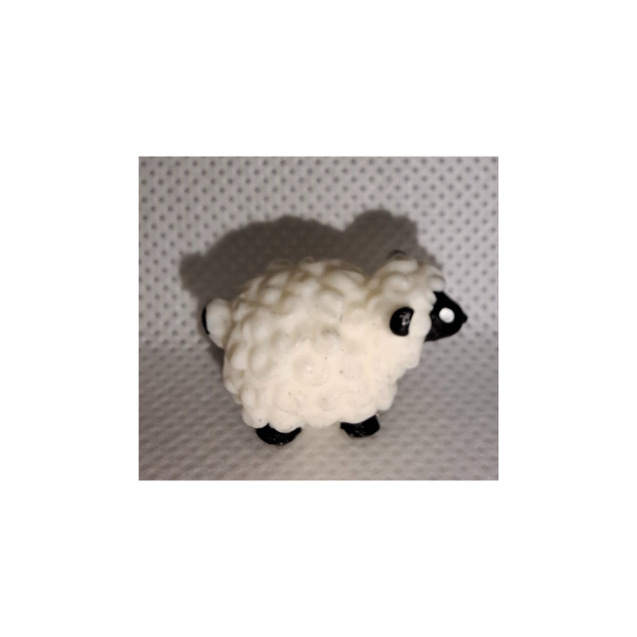 Zwei kleine realistische Mini-Schaf-Figuren aus Kunststoff auf heller Oberfläche