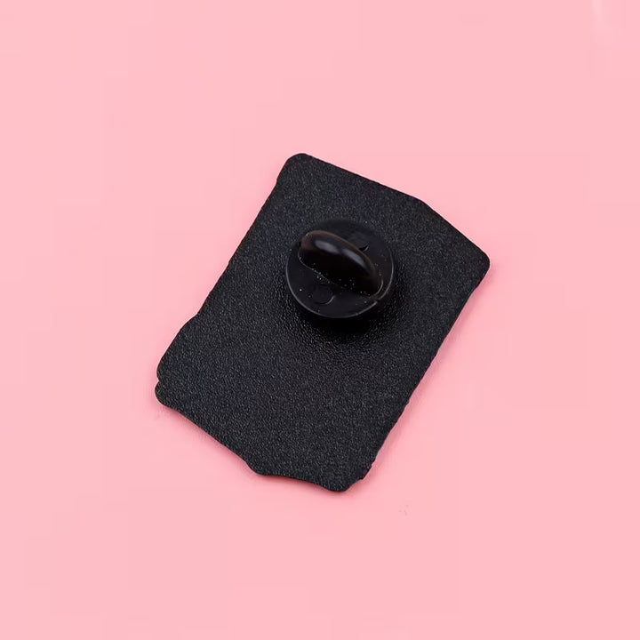 Rückseite eines Pins mit schwarzem Steckverschluss auf rosa Hintergrund