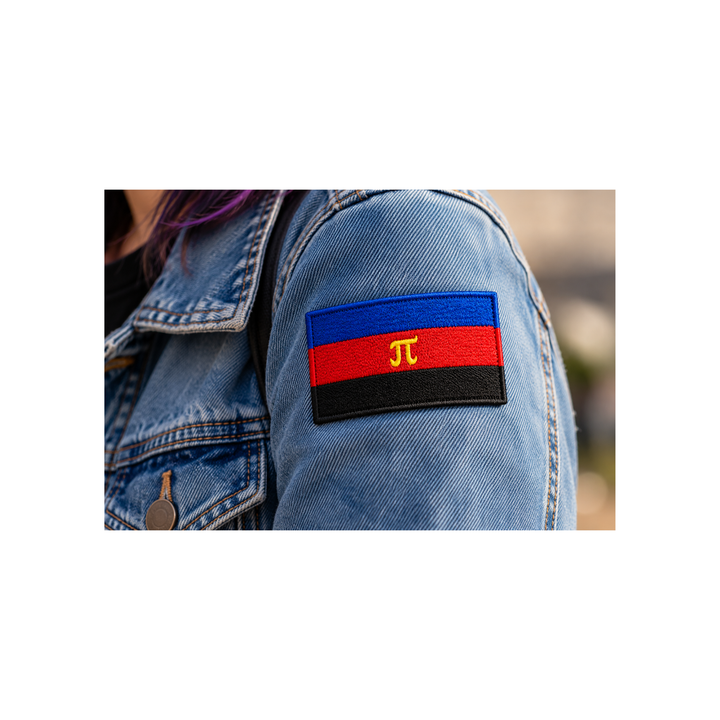 Gestickter Polyamorie Pride Patch mit Klettverschluss in Blau, Rot und Schwarz mit gelbem Pi-Symbol, 8 × 5 cm, getragen am Ärmel einer Jeansjacke.
