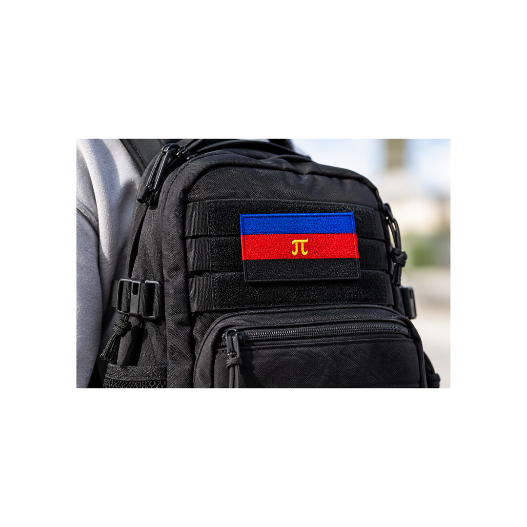 Gestickter Polyamorie Pride Patch mit Klettverschluss, 8 × 5 cm, auf einem schwarzen Rucksack mit Klettfläche. Blau-rot-schwarze Flagge mit gelbem Pi-Symbol.