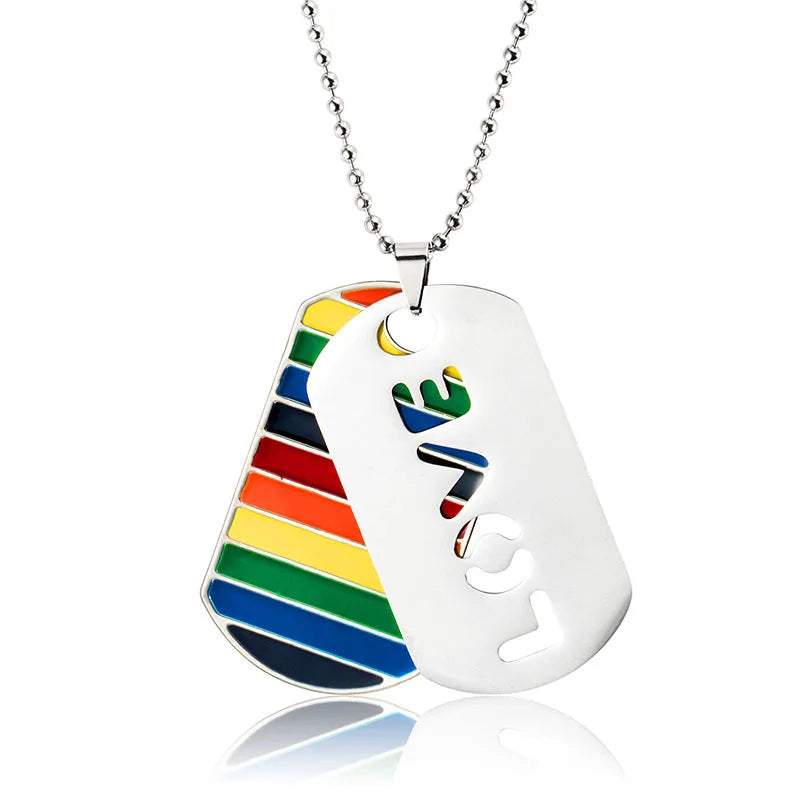 Silberne Halskette mit zwei Anhängern: einer im Regenbogen-Design und einer mit ausgeschnittenem ‚LOVE‘-Schriftzug, symbolisch für LGBTQ+ Stolz und Liebe.