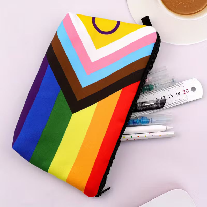 Pride Make-up Tasche von Rainbow Sheep – Kosmetiktasche mit Progress-Pride-Flagge in kräftigen Regenbogenfarben, offen mit Stiften und Lineal.