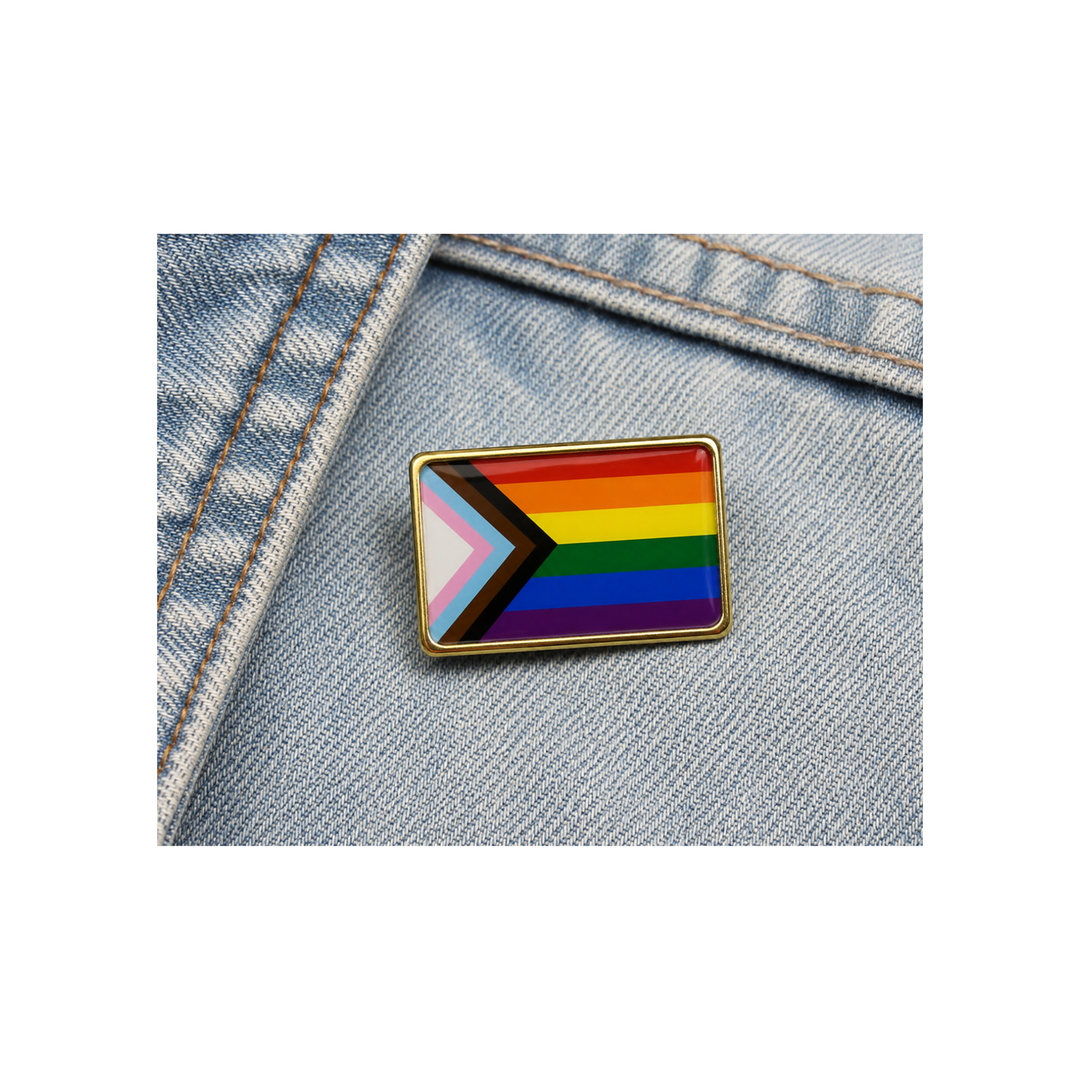 Progress Pride Flag Pin an einer Jeansjacke befestigt. Rechteckiger LGBTQIA+ Anstecker mit den Farben der Progress Pride Flag.