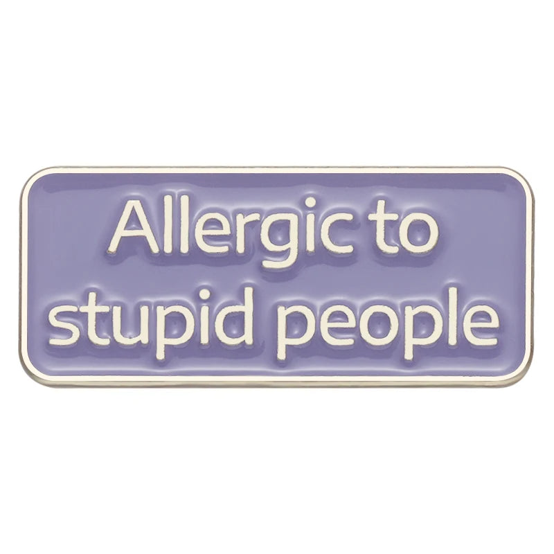 Lila rechteckiger Pin mit der weißen Aufschrift „Allergic to stupid people“ auf weißem Hintergrund.