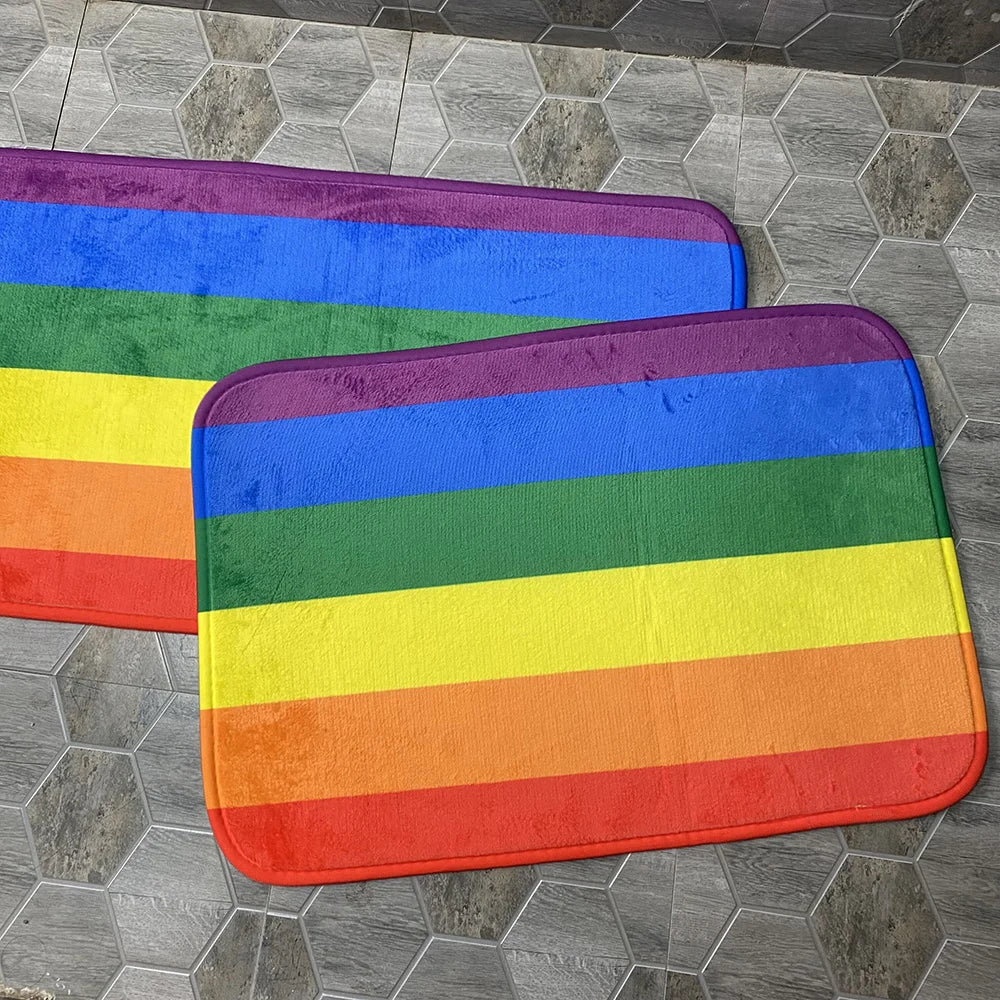 Zwei Fußmatten aus Polyester mit Regenbogenstreifen auf Fliesenboden
