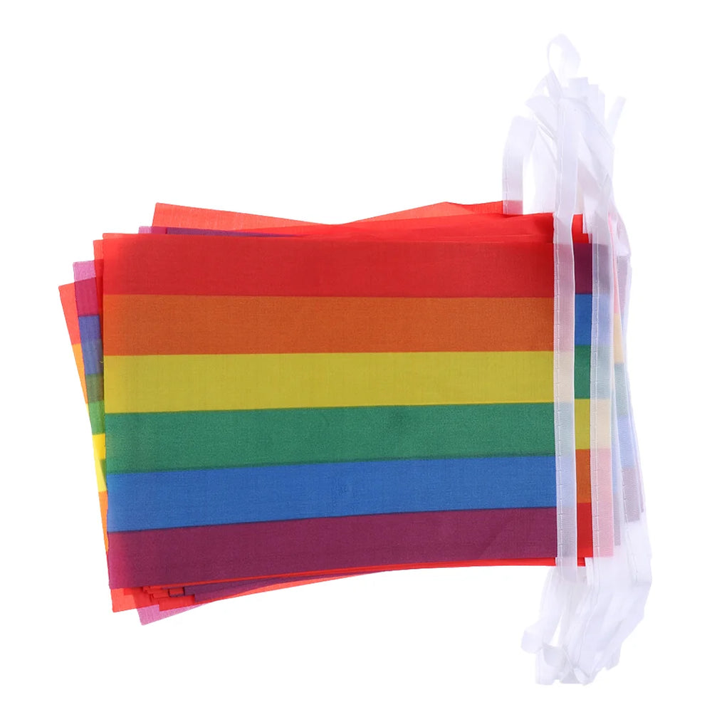 Girlanden von kleinen rechteckigen Regenbogenflaggen, gebunden mit weißen Bändern.