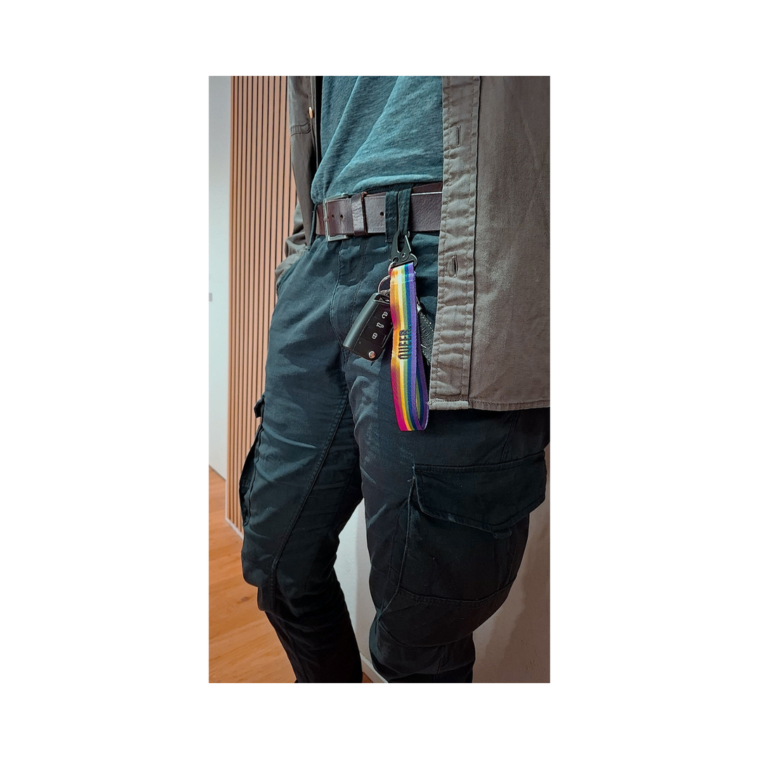 Regenbogen Schluesselanhaenger mit Autoschluessel am Hosenbund einer dunklen Cargo Hose