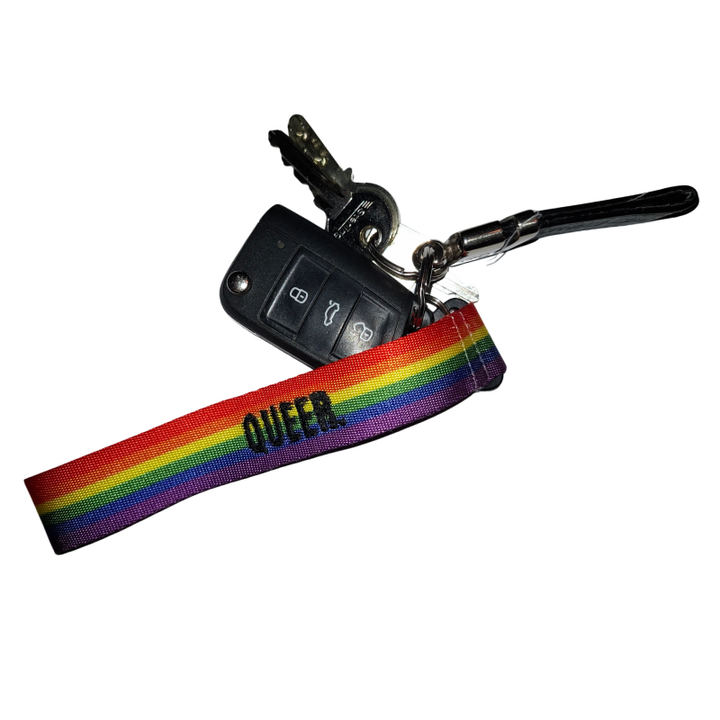 Regenbogen Schlüsselanhänger mit QUEER Schriftzug und Autoschlüssel auf weißem Hintergrund