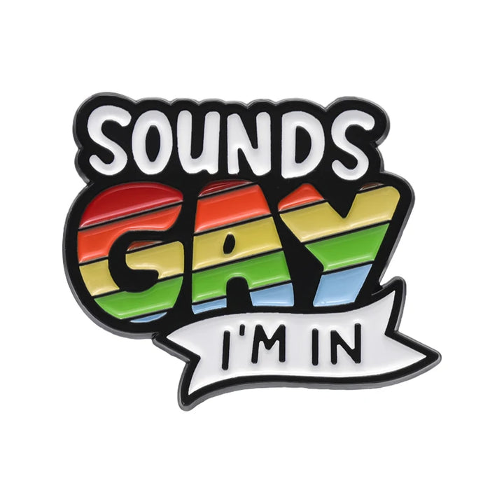 Ansteckpin mit dem Schriftzug „Sounds Gay I’m In“, wobei das Wort „Gay“ in Regenbogenfarben gestaltet ist und ein klares LGBTQ+ Pride-Statement vermittelt.
