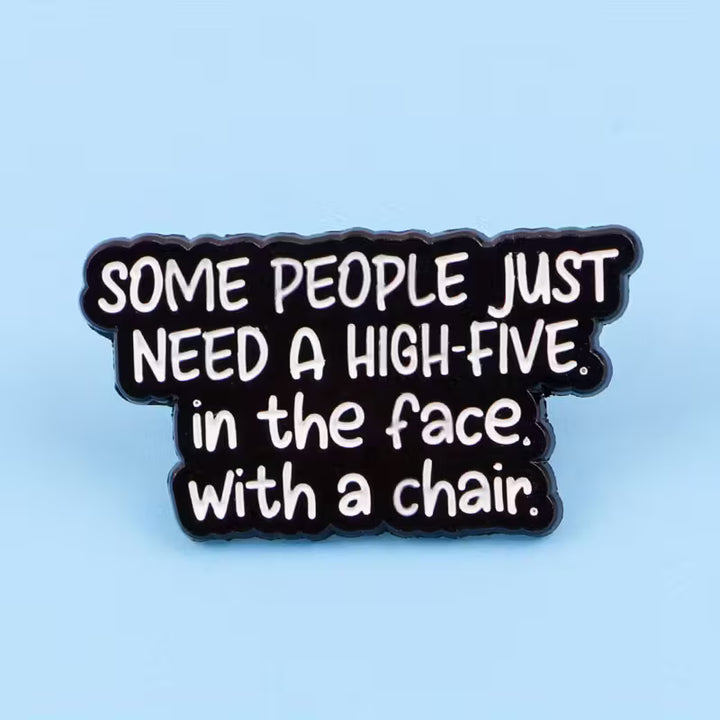 Schwarzer Statement-Pin mit weißem Text „Some people just need a high-five in the face with a chair“
