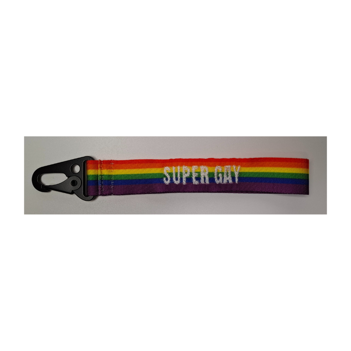 Regenbogen Schlüsselanhänger in weiss mit Aufschrift „supergay“ und schwarzem Karabiner