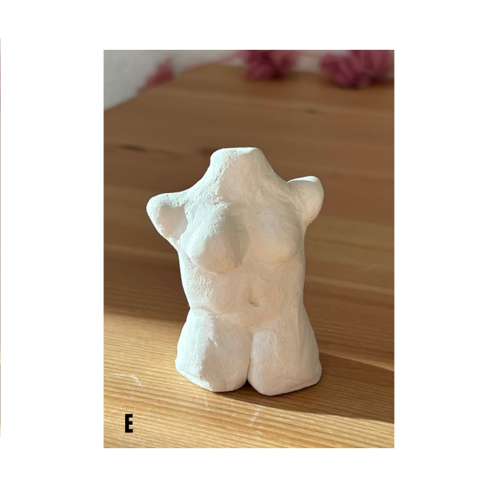 Handgefertigte Torso Skulptur aus weißer Modelliermasse als minimalistische Deko auf Holztisch