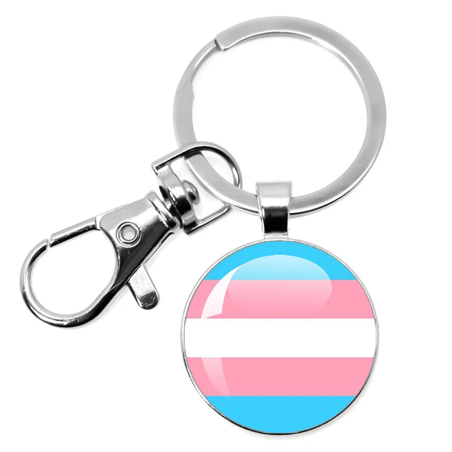 Schlüsselanhänger mit rundem Anhänger in den Farben der Transgender-Pride-Flagge auf weißem Hintergrund.