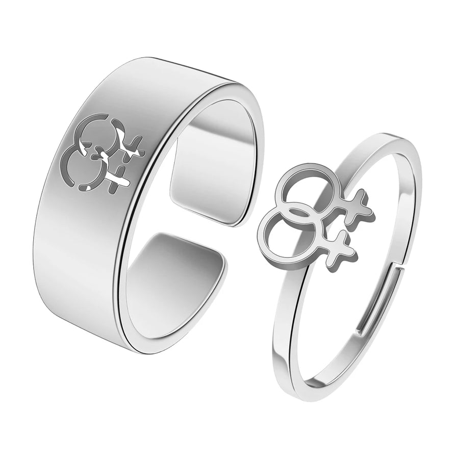 Zwei silberfarbene Edelstahlringe mit Venus-Symbol auf hellblauem Hintergrund – feministisches Schmuck-Statement
