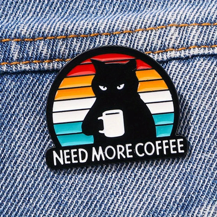 Vintage Katzen-Pin „Need More Coffee“ auf Jeansjacke – schwarzer Kater mit Kaffeetasse im Retro-Design
